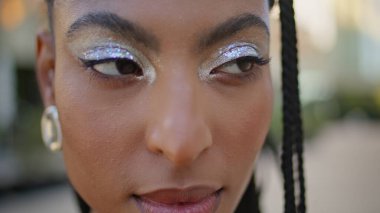 Dehşet saçan kadın, akşam sokak resmine bakıyor. Güzel esmer kadın, gün batımında yalnız başına poz veriyor. Kentsel Meydanı 'nda yaratıcı fütüristik makyajlı Afrikalı Amerikalı model kadın.