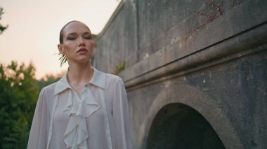 Kaygısız bayan, akşam eski taş binada yürüyor. Yaklaş. Hafta sonu terk edilmiş eski mimariyi keşfeden çekici genç bir kadın. Güzel kız eski şatonun yakınlarında gezinen kameraya bakıyor..