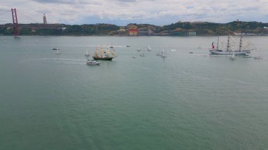 Lisboa 'da nehirde yüzen panoramik manzaralı yatlar. Arka plandaki tepelerde insansız hava aracı manzarası. Yelkenli yat seyahatinde rahat bir yaşam tarzı. Popüler turizm merkezi kavramı