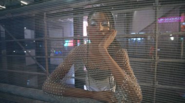 Rahat poz portresiyle gece lambası şehrine poz veren kendine güveni tam bir kadın. Güzel kıyafetler giymiş çekici bir genç kız. Akşam sokak kapanışında kameraya bakıyor. Şık, cazibeli bir kadın.