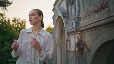 Göz kamaştırıcı gezgin dışarıdaki antik binaları keşfediyor. Eski ortaçağ duvarının yanında yürüyen zarif, sakin bir kadın terk edilmiş bir kale. Ciddi bir kız, tatilde beyaz gömleğiyle tarihi yerlerde geziniyor.