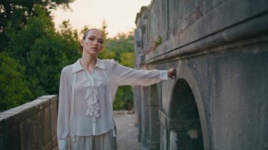 Terasta yürüyen yaşlı bir kadın terk edilmiş bir kaleye dokunuyor. Ortaçağ balkonunda tek başına gezinen muhteşem bir genç kadın. Şehvetli kız hafta sonları antik mimarinin tadını çıkarıyor..