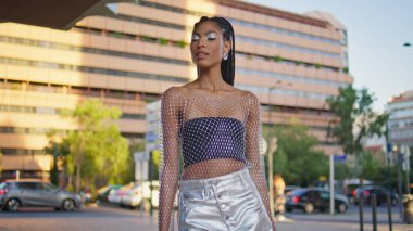 Şık esmer model, ara sokakta tek başına dolaşıyor. Muhteşem Afrikalı kadın fotoğraf makinesinde poz veriyor. Moda dünyasındaki rahat kız şehir merkezinde yaz yürüyüşünün tadını çıkarıyor. Moda insanları yaşam tarzı