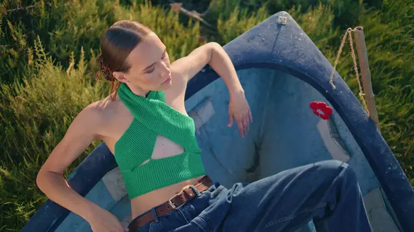 Akşam güneşi altında şık bir kadın poz veriyor. Sakin kız yaz otlağında dinlenen balıkçı teknesi. Güzel, çekici bir manken. Yaz tatilinin tadını çıkarıyor. Seren kadın dışarıda dinleniyor.