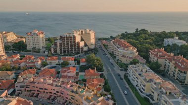 Uçsuz bucaksız mavi okyanus manzaralı güzel bir çatı şehri. Yumuşak yaz akşamları güneş ışığı altında resim gibi bir sahil kasabası. Rıhtıma giden asfalt yolda araba sürüyorum. Sıcak şehir manzarası.