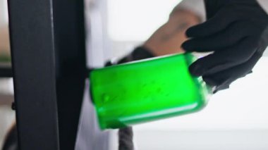 Kadın elleri stüdyonun dikey çekimine dövme ekipmanı koyuyor. Bilinmeyen lateks eldiven ustası ofisteki düzenleme masası. Profesyonel dövmeci ev salonundaki müşteri oturumuna işyerini hazırlıyor