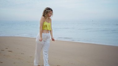 Sahilde yürüyen dansçı kız yavaşça el hareketleri yapıyor. Şehvetli bir kadın ıslak kumlu sahile adımını atarken rüya gibi uzaklığa bakıyor. Kıvırcık genç sanatçı yaz günü okyanus dalgalarının önünde dans ediyor..