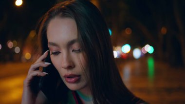 Akıllı telefonlardan konuşan güzel bir bayan gece yarısı şehir dışını kapatıyor. Karanlık akşam caddesinde bekleyen çekici genç bir kadının portresi. Harika bir iş kadını konuşuyor..