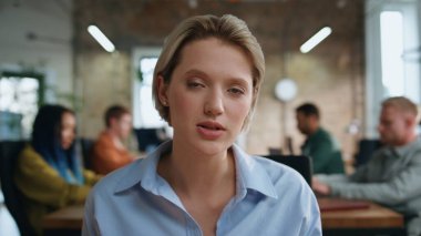 Ofisteki video toplantısında POV videosunu kapatan mutlu iş kadını konuşuyor. Çekici, gülümseyen kadın internet üzerinden müşteriye danışıyor. Patroniçe iş yerindeki uzak konferansta konuşuyor..