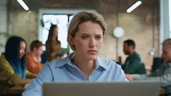 Displeased woman reading bad news at laptop informing office team sitting table close up. Worried businesswoman with coworkers feeling despair at business failure. Colleagues expressing dissatisfying.