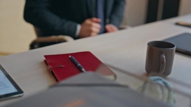 Yakından kalem adam alarak kabinede işe başlıyor. İş yerinde takım elbise düzelten resmi giyimli adam not defteri açıyor. Ciddi iş adamı dizüstü bilgisayarı açıyor ve notları programa göre ayarlıyor.