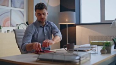 Kendine güvenen adam modern ajans ofisinde çalışmaya başlıyor. Ciddi bir iş adamı tek başına notları kontrol ediyor. Odaklanmış başlangıç bilgisayarı, sabahları kahve fincanı alan e-postaları kontrol etmek için açılır.