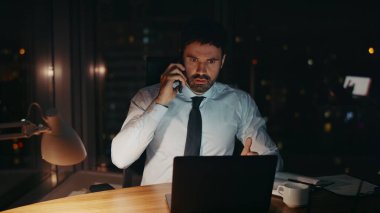 Endişeli CEO 'nun ofis bilgisayarından yaptığı konuşma akşam üzeri kapanır. Sinirli iş adamının telefonla araması tatmin olmamış iş yerinin gece masasında oturmasıyla sonuçlanır. Sinirli yönetici akıllı telefondan konuşuyor..