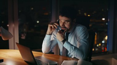 Yorgun girişimci iş ortaklarını arıyor. Gece geç saatlerde ofis masasını kapatıyorlar. Ciddi bir iş adamı telefonda gece iş bitiminde endişeli bir şekilde konuşur. Yorgun yönetici telefonda dizüstü bilgisayarla konuşuyor..