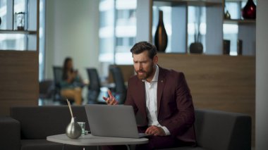 Gergin adam, ofisteki dizüstü bilgisayarı kullanarak yanlışlıkla video görüşmelerini karıştırıyor. Stresli motivasyonsuz iş adamı şirkette çalışırken hayal kırıklığına uğruyor. El kol hareketi yapan sakallı adam başarısızlığa tepki veriyor.