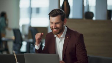 Modern ofiste dizüstü bilgisayarın başarısını kutlayan heyecanlı adam. Şirket binasında mutlu gülümseyen yönetici kazanma anlaşması başarısı. Rahat koltukta çalışan neşeli, varlıklı avukat.