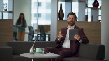 Büyük şirket binasında tablet bilgisayardan bahseden neşeli bir adam. Kabinedeki rahat koltukta neşeli bir girişimci video konferansı veriyor. Modern açık alanda başarılı bir profesyonel avukat.