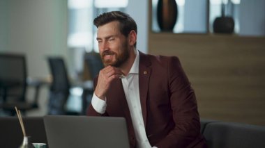 Zengin güler yüzlü girişimci büyük dolapta dizüstü bilgisayarı daktilo ediyor. Ofise bakan neşeli, çekici, sakallı avukat. Başarılı neşeli kurumsal emlakçı modern iş konsepti