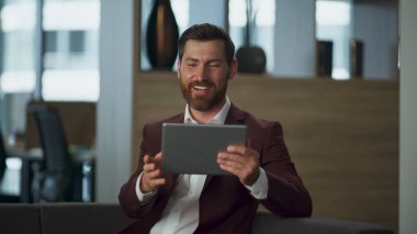 Şirket içi video konferansından bahseden gülümseyen milyoner. Şirketimizden finansal tablet bilgisayarla konuşan neşeli sakallı bir iş adamı. İyi pazarlama konuşmaları.