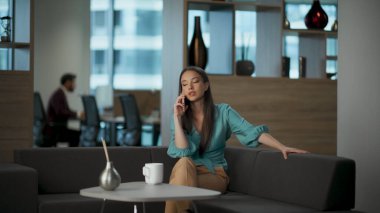 İş yerinden arayan ciddi bir girişimci var. Odaklanmış sakin yönetici koltukta oturarak iş meselelerini tartışıyor. Esmer iş kadını kahve içiyor ve internette konuşuyor. İş hayatı konsepti 