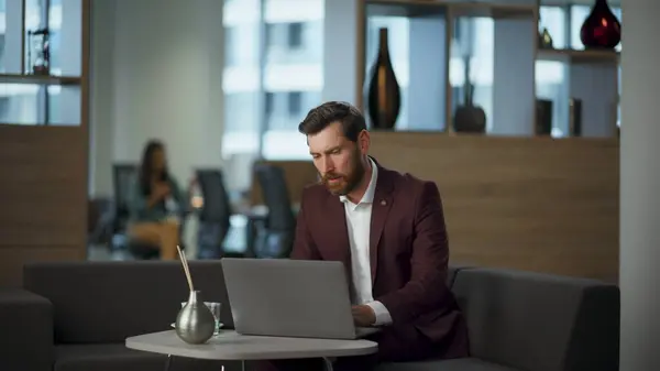 Sad boss feeling disappointed about problems in work looking computer screen at office interior. Nervous man reacting bad news at laptop workplace. Frustrated stressed businessman tired of troubles