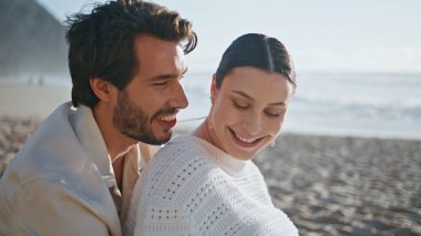 Kumsalda oturan evli bir çift birlikte gülüp eğleniyor. Tatlı genç eşler yaz akşamları deniz kıyısında aile pikniğinin tadını çıkarıyorlar. Gülümseyen kaygısız ruh eşleri kıyıda dinleniyor..