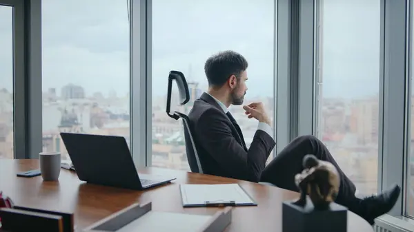 Serious manager thinking work issues sitting comfortable chair luxury office close up. Pensive bearded business man looking laptop worried career perspectives. Unmotivated worker boring in workplace.