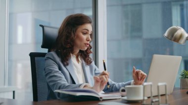 Bilgisayardan konuşan mutlu bir çalışan, video konferans masasında oturuyor. Neşeli iş kadını videosu tatmin edici iş sonuçlarını arıyor. Kız müdür internet toplantılarında iyi haberleri paylaşıyor.