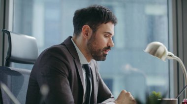 Modern ofiste bilgisayar kullanan bir iş adamı video eğitiminde konuşuyor. Kendine güvenen sakallı yönetici internet kameralarıyla sohbet ediyor. Uzaktaki konferansta ciddi bir işçi konuşuyor..