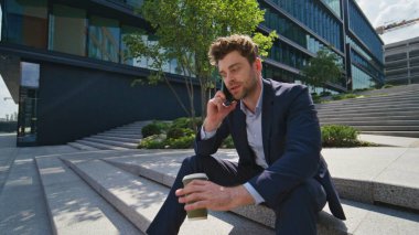 Başarılı bir danışman, güneşli bir günde sokak merdivenlerinden arıyor. Ciddi bir iş adamı dışarıda kahve tutarak akıllı telefondan iş tartışıyor. Zarif yönetici cep telefonundan konuşuyor. Kamera hareket ediyor.