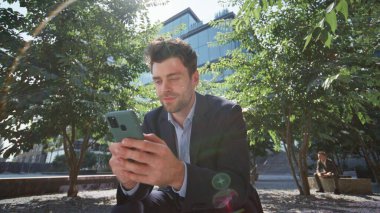 Zeki serbest çalışan cep telefonlu güneş ışığında Green Street 'te oturuyor. Yakışıklı, rahat iş adamı parkta akıllı telefon mesajı yazıyor. Kendine güvenen yönetici, iş gününden sonra cep telefonuna bakarken rahatlıyor.