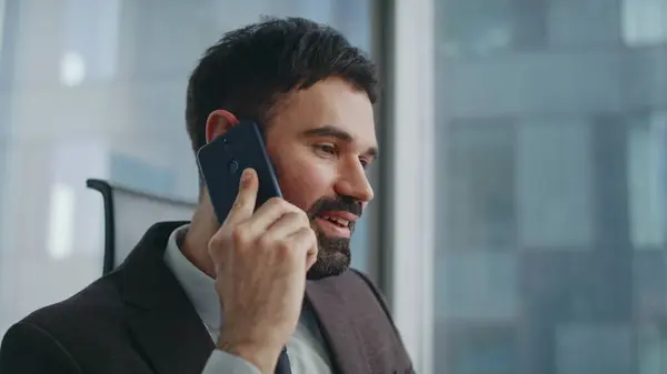 Banker discussing deal at phone conversation in office close up. Portrait of handsome successful businessman conducting telephone negotiation with partners. Confident ceo manager calling at workplace.
