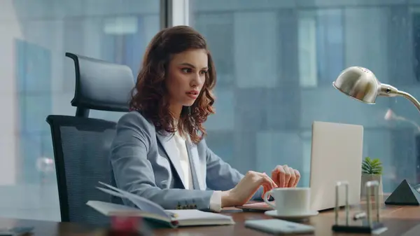Business woman shocked failure reading bad news at laptop screen sitting office close up. Attractive young lady boss feeling despair from job problem working at computer. Stressed girl worker worried.