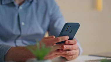 Akıllı telefonları tutan adam şirket ofisini kapatıyor. Gülümseyen iş adamı cep telefonu ekranı görüntüsü çevrimiçi uygulamayı kapalı alanda tarıyor. İş yerindeki rahat yönetici mesajlaşması.