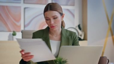 Meşgul kadın rahat ofis kapanışında belgeleri inceliyor. Şirket avukatı, kağıt okuyor, kontratı kontrol ediyor. Modern kabinede finansal rapor hazırlayan başarılı bir iş kadını.