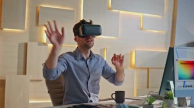Kreatif ofis kapanışında VR gözlükleri kullanıyor. Görünmez arayüze dokunan profesyonel geliştirici artırılmış gerçeklik. İş yerinde holografik simülasyonla çalışan gözlüklü sanal tasarımcı.