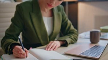 Kapalı mekandaki deftere notlar yazan kadın elleri. Çok çalışan ciddi bir iş kadını bilgisayar monitörüne bakıyor ve iş yerinde yoğun olduğunu hissediyor. Profesyonel okuma görevleri ofiste tek başına düşünmek