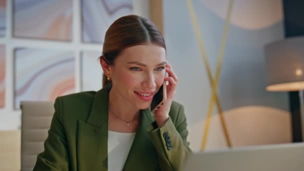 近代的なオフィスの閉鎖で携帯電話を話す笑顔の幹部 スマートフォンを活用したリラックスしたコーポレートマネージャー 電話でパートナーと笑うケアフリーの女性従業員 — ストック動画