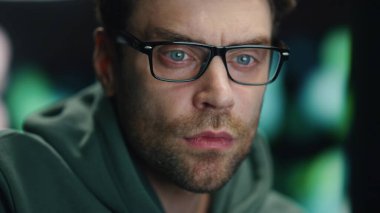 Kapanış adamı kodlayıcısı gece veri tabanında çalışıyor. Gözlüklü ciddi geliştirici sadece iş yerinde bilgisayar monitörü programlama koduna bakıyor. Kontrol odasında masaüstü bilgisayarına bakan akıllı bilişim programcısı