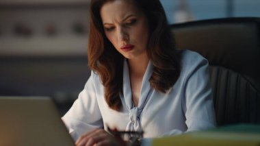 Akşam kabinesinde dikkati dağılmış bir akıllı telefon mesajı. Elinde cep telefonu olan neşeli bir bayan karanlık ofiste tepki veriyor. Gülümseyen iş kadını gülen yüzle iyi haber e-postası okuyor.