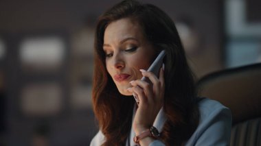 Patroniçe cep telefonu sohbetini akşam ajansında bitiriyor. Gülümseyen başarılı kadın deri koltukta oturan cep telefonunu seçiyor. Memnun iş kadını geç saatlere kadar ofiste çalışıyor.