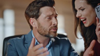 Kapalı çekim, iş çifti kabinede tartışıyor. Öfkeli duygusal yönetmen iş yerindeki meslektaşına el kol hareketi yapıyor. Akıllı telefon görüşmesinde sorunları çözen kadın partner gergin hissediyor