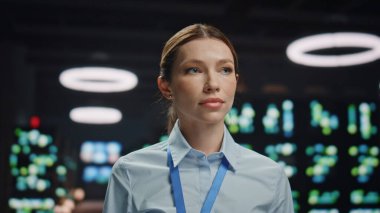 Portre işkadını veritabanı poz veriyor. Kamera görüntüsü alan sistem yöneticisi kadın siber güvenlik bürosuna yakın çekim yapmış. Resmi giyinmiş ciddi bir kadın sunucu odasına bakıyor.