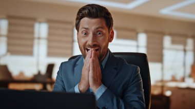 Işık kabinesi kapanışında başarı kazanan heyecanlı adam. Duygusal iş adamı, görevde başarıyı kutlamakla karşı karşıya. Mutlu resmi takım elbiseli patron evet diye bağırıyor. Deri koltukta el sallıyor.