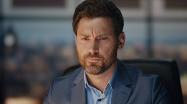 Ofiste çalışan düşünceli bir çalışan. Yakın plan. Yorgun iş adamı iş yerinde geç saatlere kadar kalan mali raporları okuyor. Kahve fincanı içen yakışıklı bir yönetici. Lamba ışığında CEO planlama stratejisi