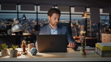 Düşünceli patron gece kabinesinde telefon bildirimini kontrol ediyor. Odaklanmış adam panoramik karanlık ofiste akıllı telefon okuyor. Akıllı yönetmen bilgisayar işyerinde gezici ekran gibi görünüyor