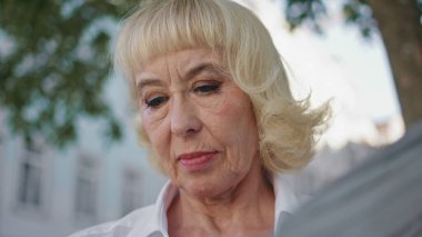 Emekli bir adam sokakta gazete okuyor. Ciddi zengin yaşlı kadın açık hava restoranında dergi makalesine bakıyor. Güzel, yaşlı bir kadın hafta sonu basınından keyif alır..