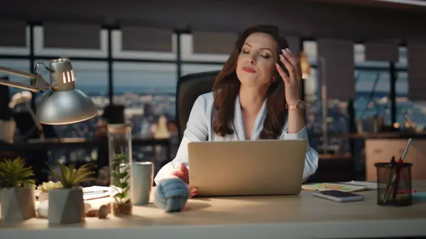 Disappointed business woman nervous in dark office closeup. Upset chief looking laptop screen making face palm gesture at panoramic windows agency. Sad lady feeling stressed reacting at work problems