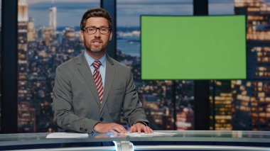 Televizyon sunucusu yeşil ekran akşam haberlerini sunuyor. Profesyonel sunucu haber bültenini modern stüdyoda bitiriyor. Sakallı spiker Chroma Key TV odasından izleyicilere veda ediyor.