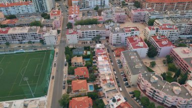 Akşam alacakaranlık manzaralı panoramik deniz kenarı kasabası. Okyanus kıyısına kurulmuş güzel Akdeniz şehri. Kırmızı çatıları olan pitoresk şehir binaları yazın alacakaranlıkta sıcak kentsel bölgeler..